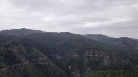 video de dron frontal de la "hora dorada" que se mueve sobre las montañas de sh22 en albania, sobre la carretera en la cima de la colina