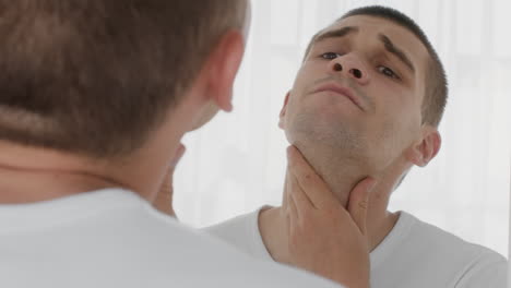 man checking his face in a mirror