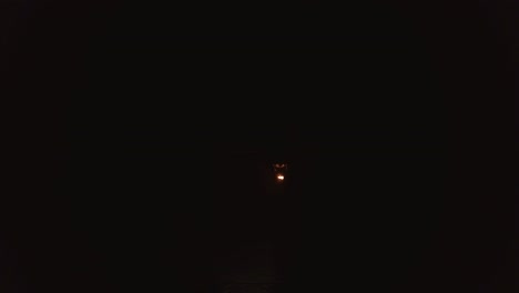 joven hombre rubio exhala una gran corriente de fuego haciendo bola de fuego en el aire de noche