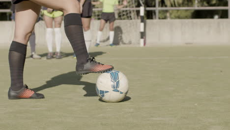 cámara lenta de una jugadora de fútbol con la pierna en el balón de fútbol preparándose para dar un tiro libre