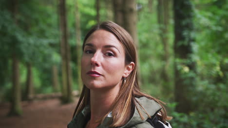 head and shoulders portrait of woman hiking through woodland