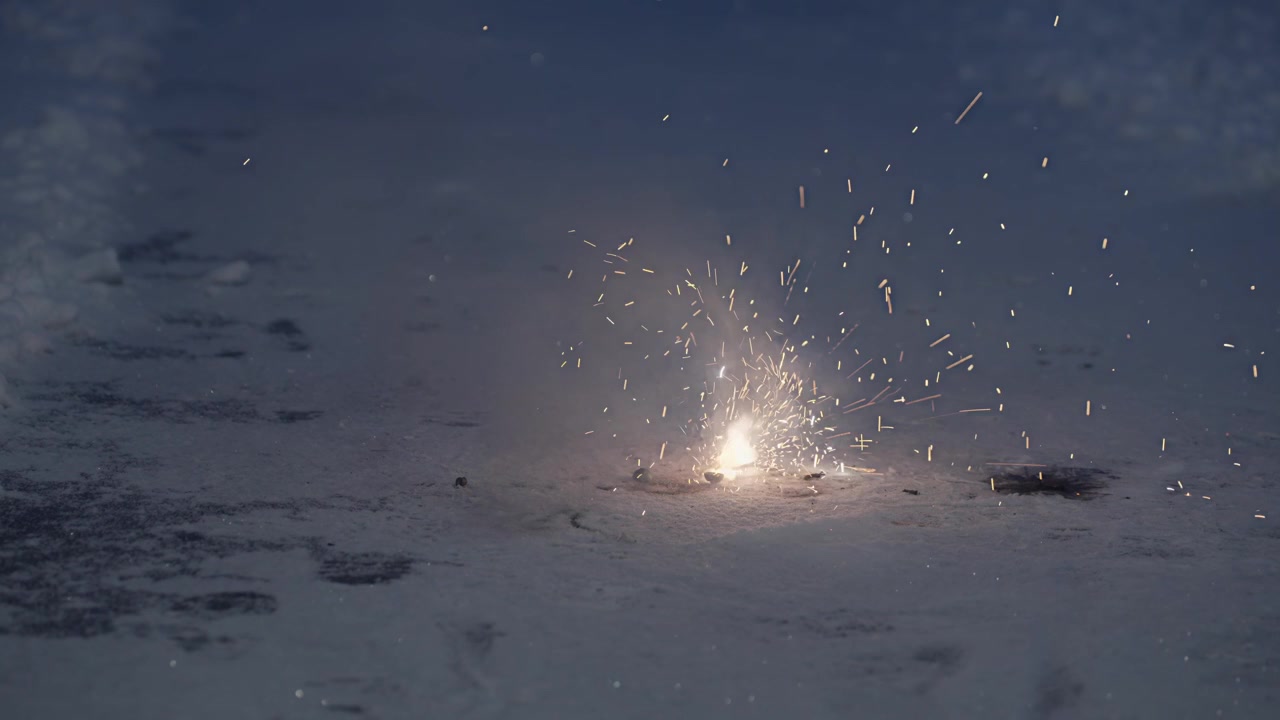 Dopo diversi tentativi, un uomo accende un fiammifero e innesca un piccolo fuoco d'artificio a terra che emette scintille prima di spegnersi rapidamente