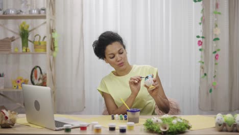mujer pintando huevos de pascua - tutorial de artesanía en línea