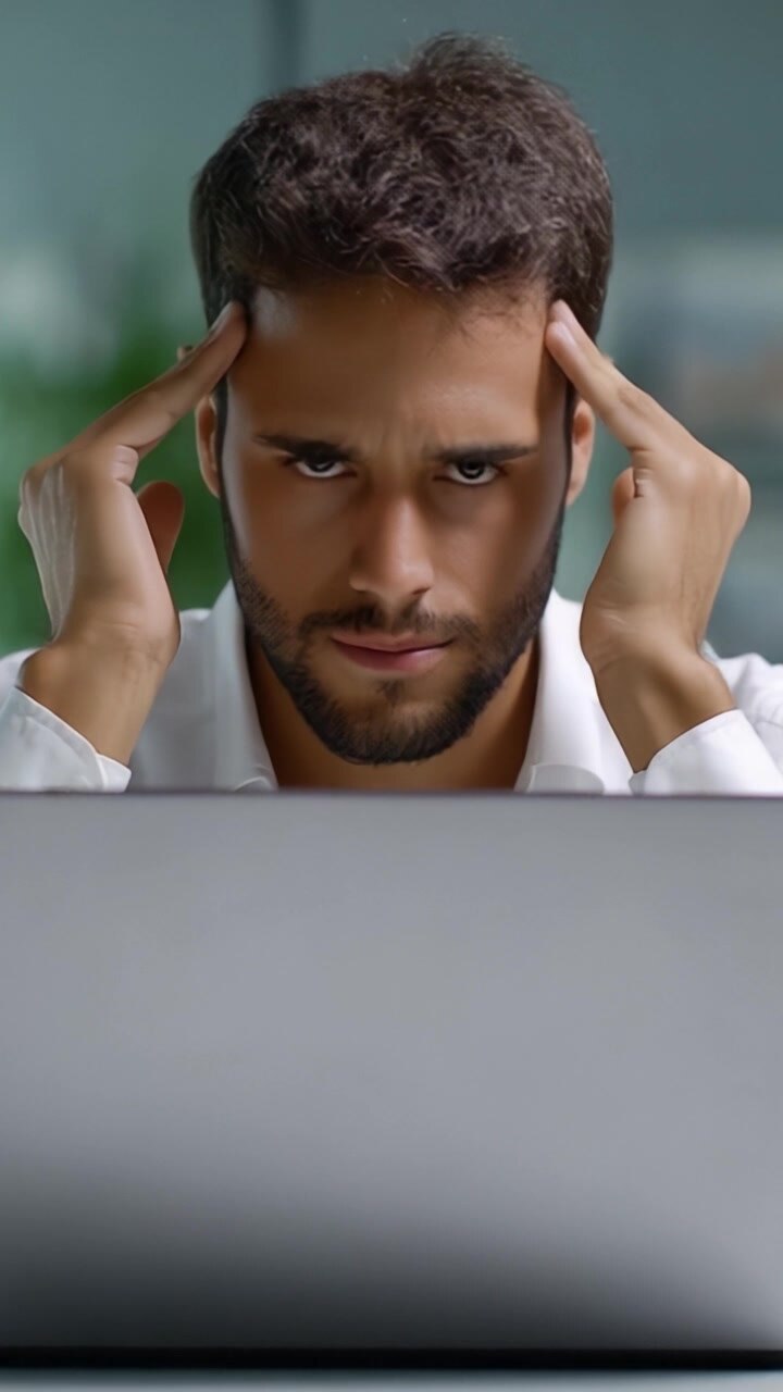 A focused individual expresses deep concentration and mental strain while working on a laptop, illustrating the challenges of modern problem-solving and productivity.