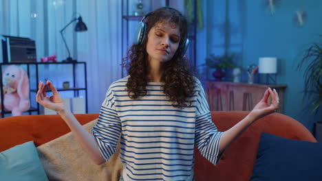 mujer joven en el sofá de casa meditando con los ojos cerrados con pensamientos concentrados, escuchando música