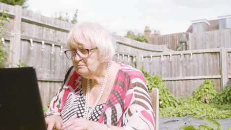 Close-up-on-elderly-woman-as-she-types-on-a-laptop-peacefully