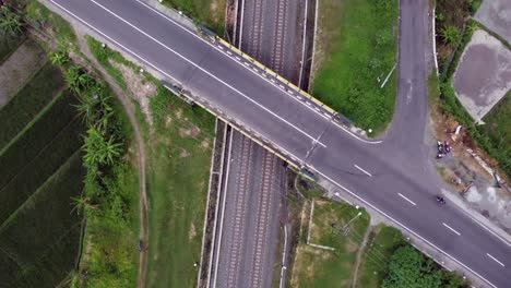 Vista-Aérea-De-La-Vía-Férrea-En-Los-Campos-De-Arroz-Y-Debajo-De-La-Carretera