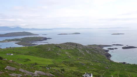 Tilt-down-shots-of-beautiful-idyllic-Ring-of-Kerry-landscape-with-islands-and-green-mountains,-Ireland