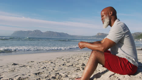 Älterer-Afroamerikaner,-Der-Am-Strand-Sitzt