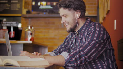 Chico-Guapo-Usando-Una-Computadora-Portátil-En-Una-Cafetería