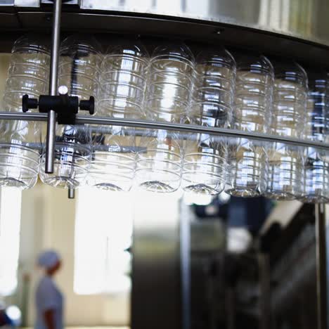 cooking oil production line. empty bottles hanging on a conveyor. automated factory for the production of olive oil. concept of food industry.