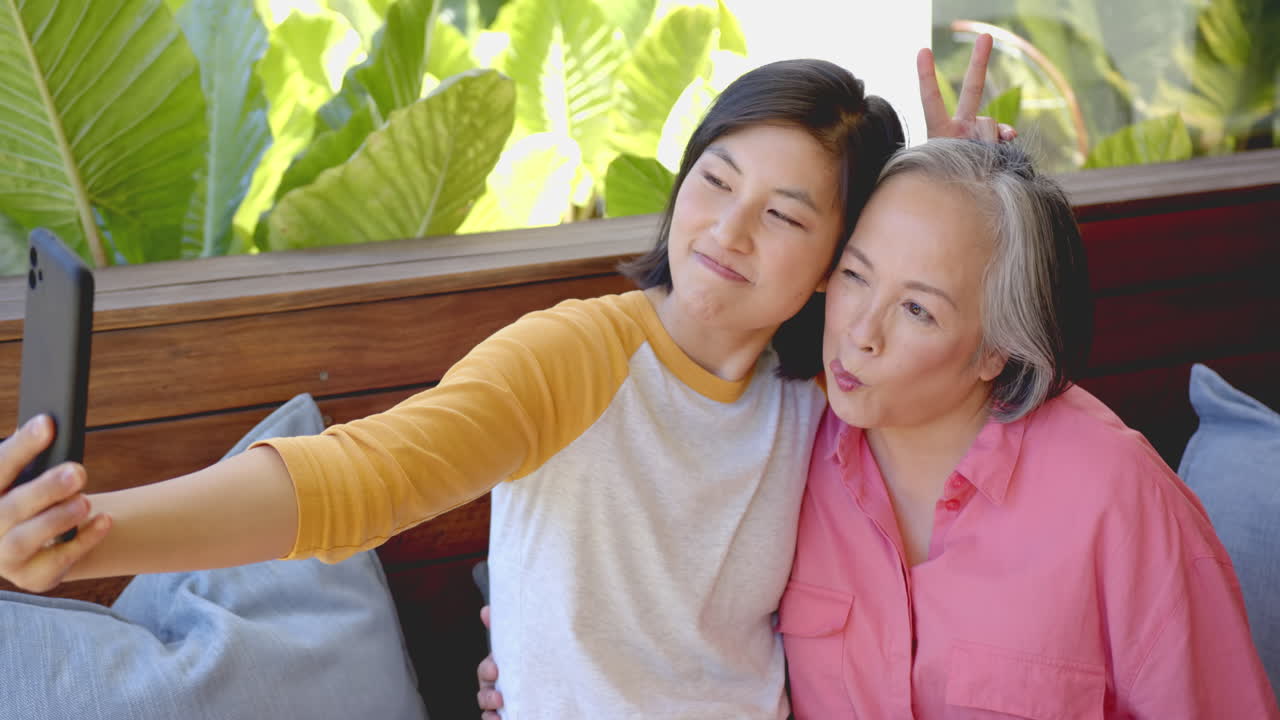 Taking selfie, two women posing and making funny faces together
