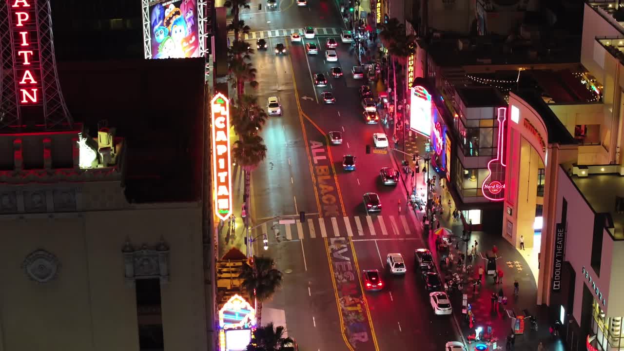 Neon signs and nighttime traffic on Hollywood Boulevard, California with All Black Lives Matter painted on the street