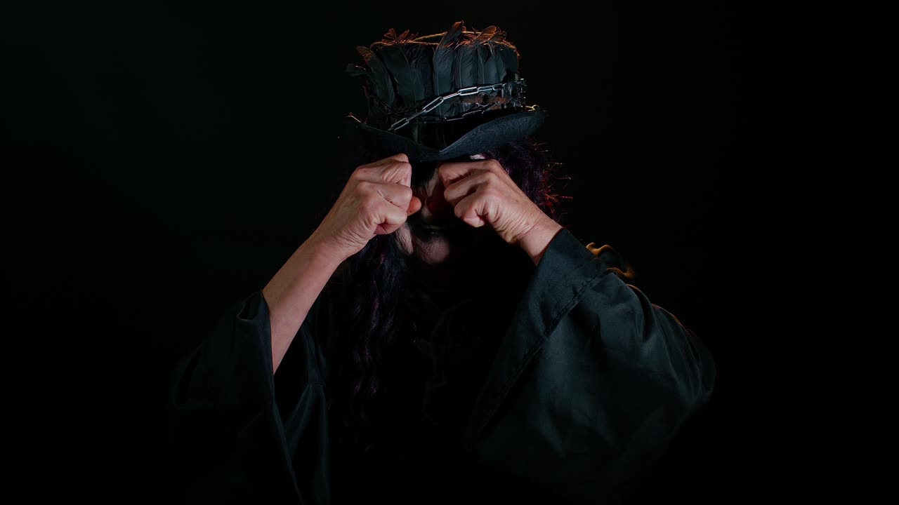 Upset disappointed sinister woman in costume of Halloween witch wipes tears and cries from despair