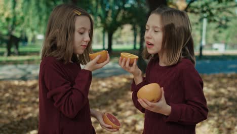 Dos-Hermanas-Caucásicas-Comiendo-Naranjas-Y-Pomelos-En-Otoño.