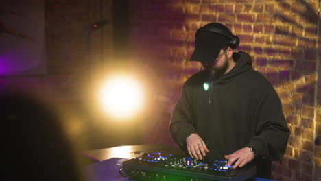 man with black cap djing at the disco