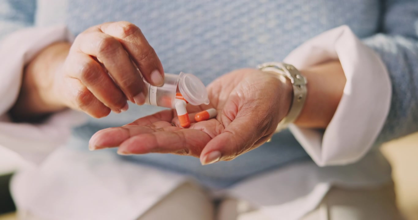 Senior Woman Pouring Medication Capsules into Her Hand