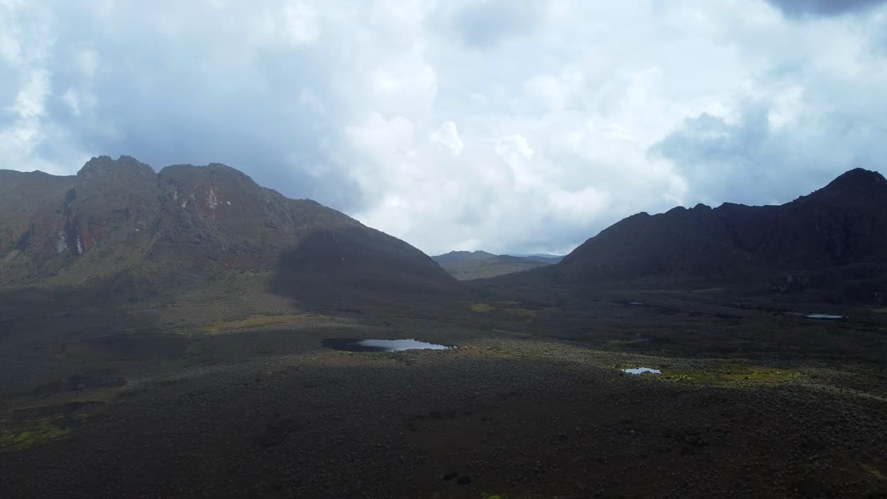 el paisaje se despliega debajo, un tapiz de colinas onduladas, valles verdes y picos envueltos en niebla que se extienden hasta el horizonte.