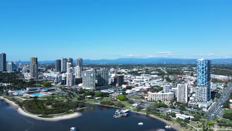 towering buildings and aquatic centre built on the foreshore amongst a urban city sprawl