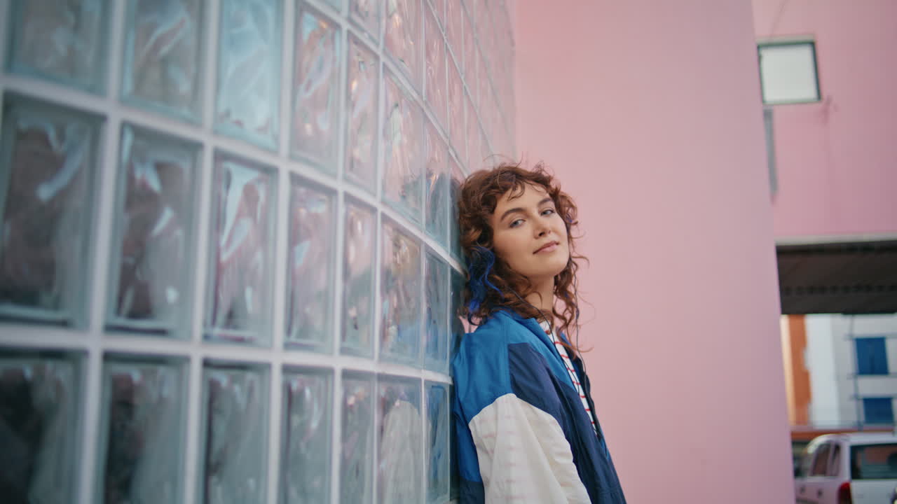 행복한 스터가 헤드폰으로 음악을 듣고 야외에서 카메라를 가게 보고 있습니다.