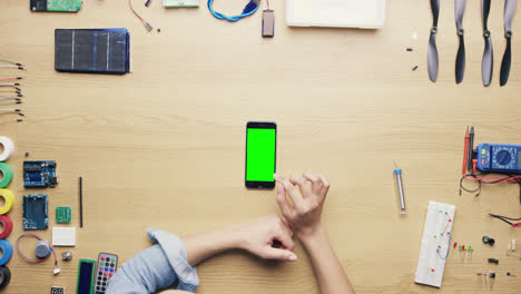 Top-view-woman-software-engineer-using-smartphone-touchscreen-at-desk-from-above---Red-Epic-Dragon