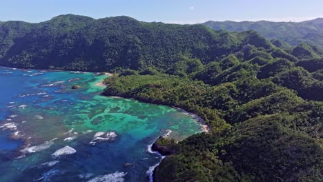 Picturesque-Dominican-Republic-Island-with-green-mountains,-crystal-clear-blue-bay-water-and-coral-reef