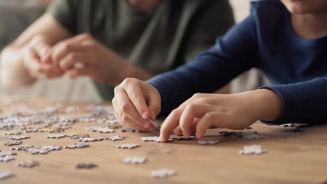 Close-up-video-of-father-and-son-solving-jigsaw-puzzle