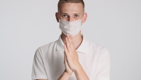 blond man with face mask, rubbing his hands