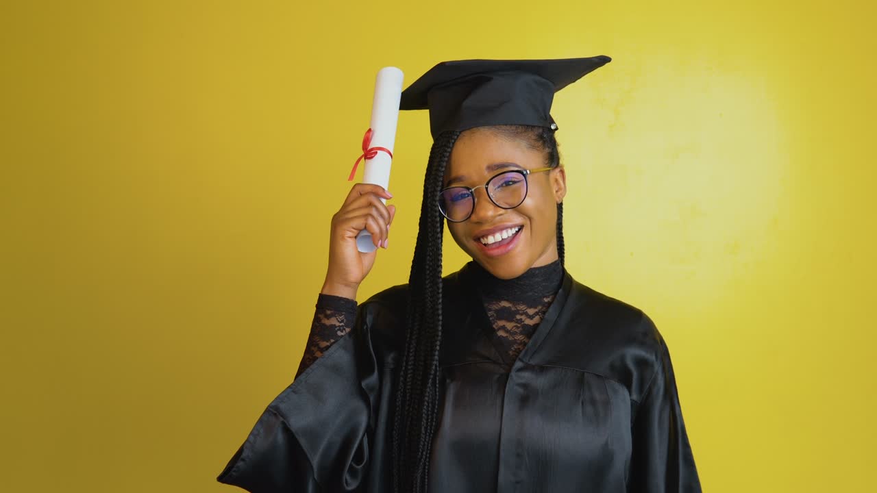 una alegre estudiante de posgrado tiene un diploma internacional y juega con sus gafas y expresa felicidad y emociones positivas sobre su logro. doctor en filosofía