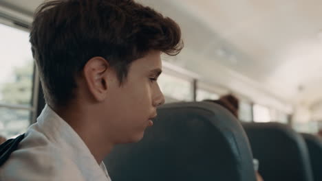 Teenager-boy-talking-passenger-in-school-bus-close-up.-Pupil-sitting-transport.