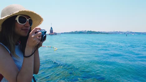 cámara lenta: hermosa chica toma fotos del bósforo, un destino popular en la ciudad de uskudar, estambul, turquía