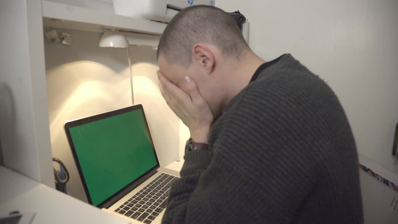 Tired Man Check The Time On His Wristwatch And Put Both Hands On His Face In Front Of His Laptop .- closeup shot