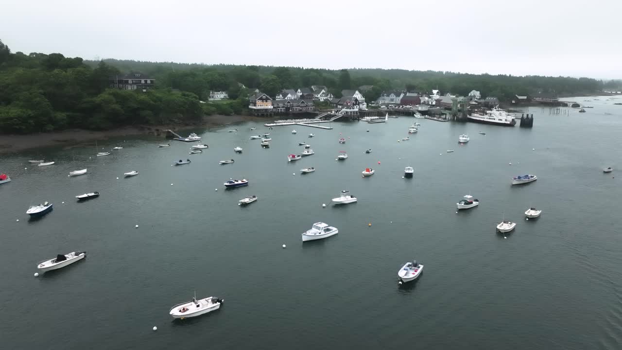 Aerial view of North Haven, Maine, showcasing a charming coastal village, boat-filled harbor, and surrounding forested islands on a calm summer day.