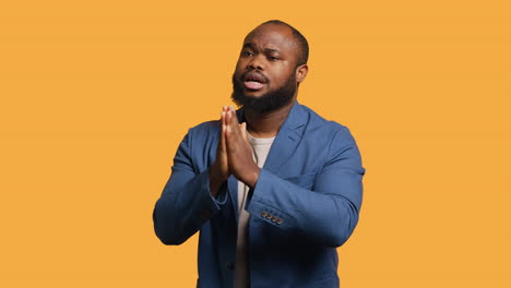 man putting hands together in apology gesture, asking for forgiveness