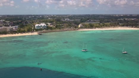 aerial view overlooking sailboats on the coastline of nassau, bahamas - pan, drone shot