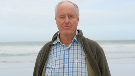 front view of old caucasian senior man standing at beach 4k