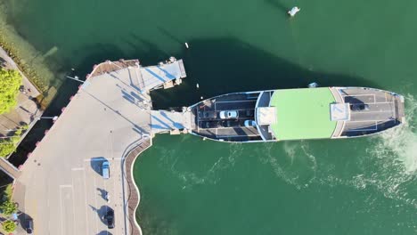 Top-down-aerial-drone-shot-of-car-ferry-offloading-bicycles-and-cars-at-Meilen-on-Lake-Zürich-in-Switzerland