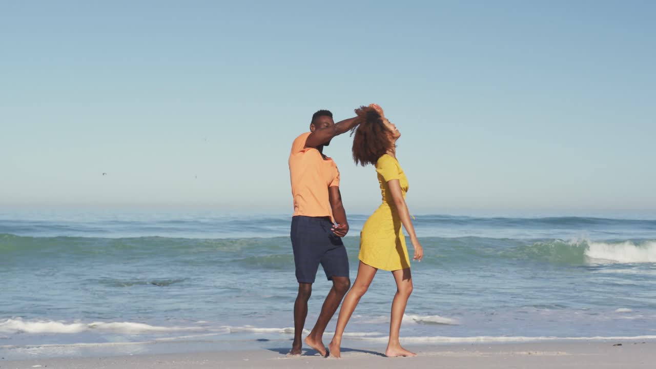 African American couple dancing seaside