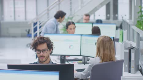 big busy corporate office with two rows off businessmen and businesswomen working on desktop computers. bright open space office with businesspeople and salespeople