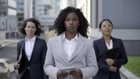 multiethnic businesswomen walking on street