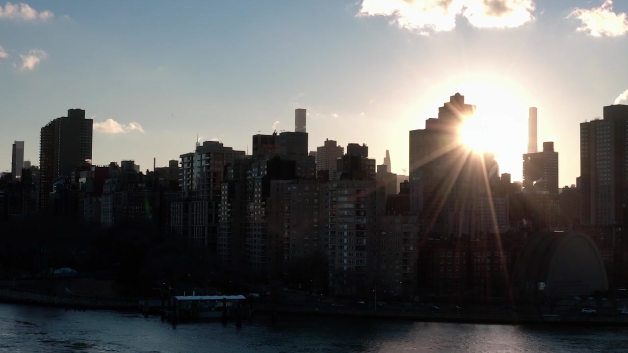 Sunrise over New York City with buildings and clouds in the sky