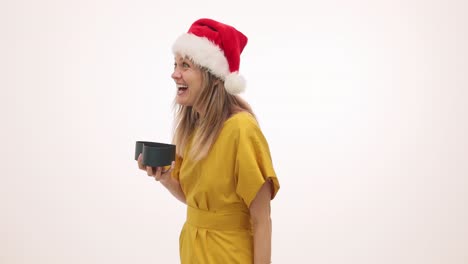 woman in santa hat unboxes a surprise gift