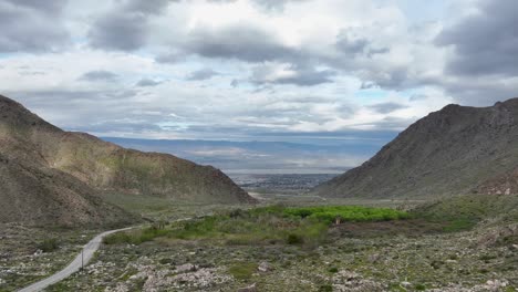 montañas con carretera en el medio con manantiales de palma desierto por delante