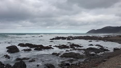 Salvajes-Olas-Blancas-Rompiendo-Sobre-Rocas-A-Lo-Largo-De-La-Hermosa-Y-Escarpada-Costa-Remota-En-Wellington,-Nueva-Zelanda-Aotearoa