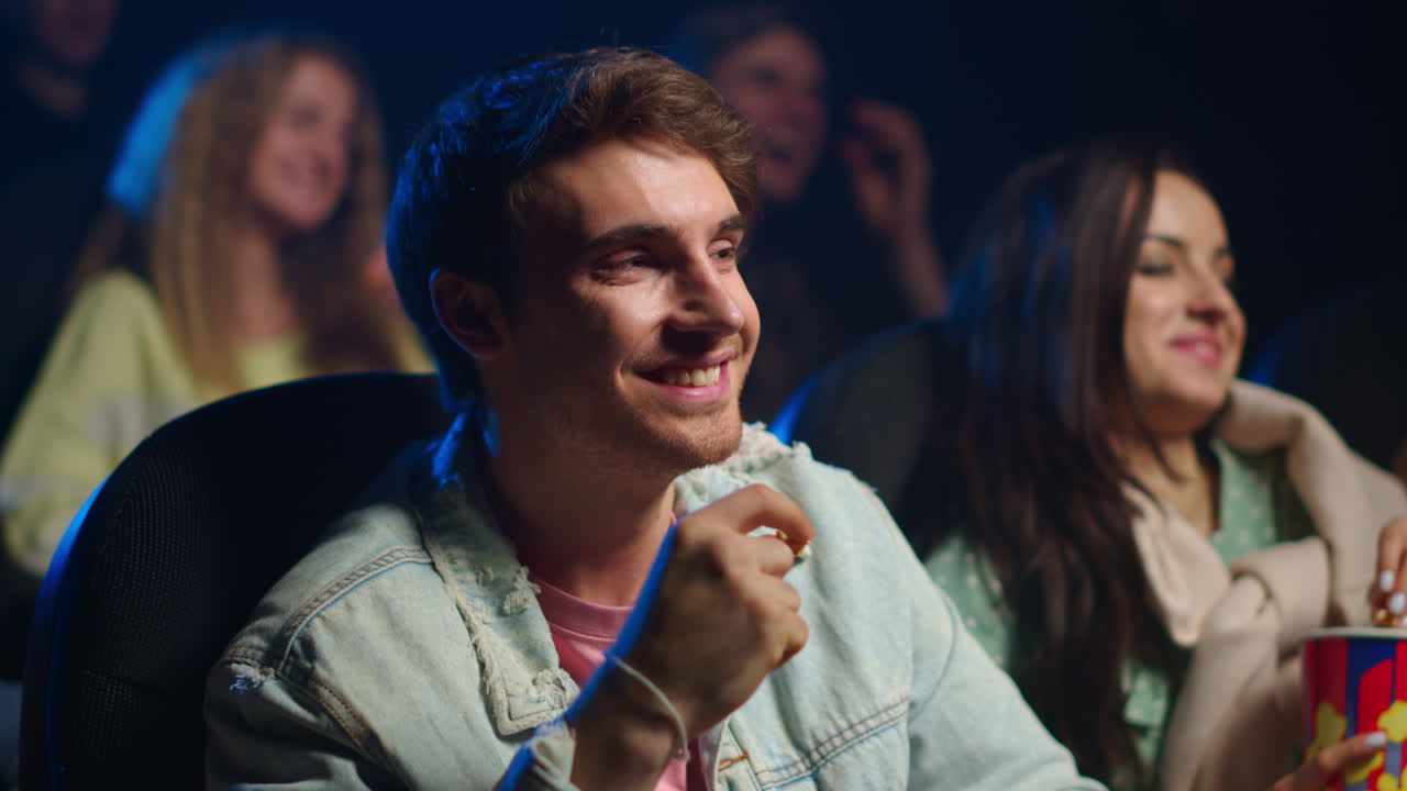Happy couple eating in movie theater