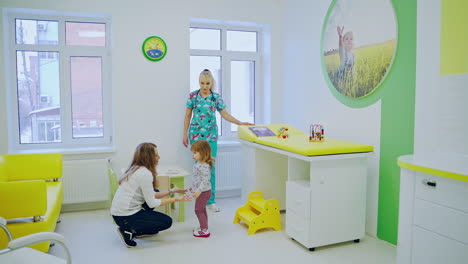 pediatrician examining little girl. cute kid patient visiting female doctor pediatrician