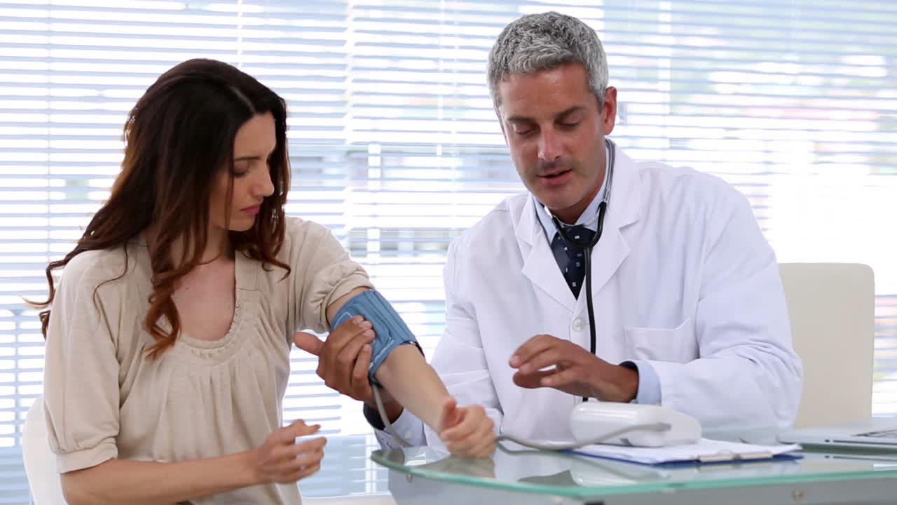 Medico che controlla la pressione sanguigna del paziente