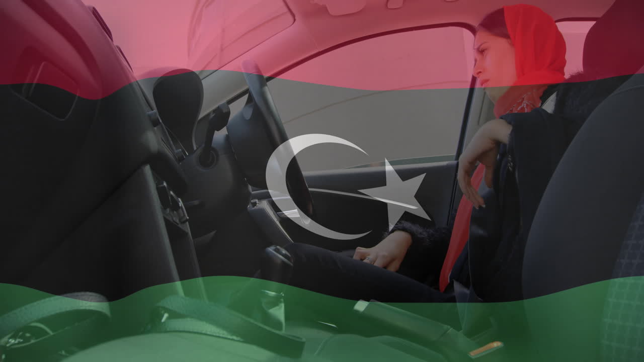 In car, woman looking contemplative with Libyan flag animation overlay
