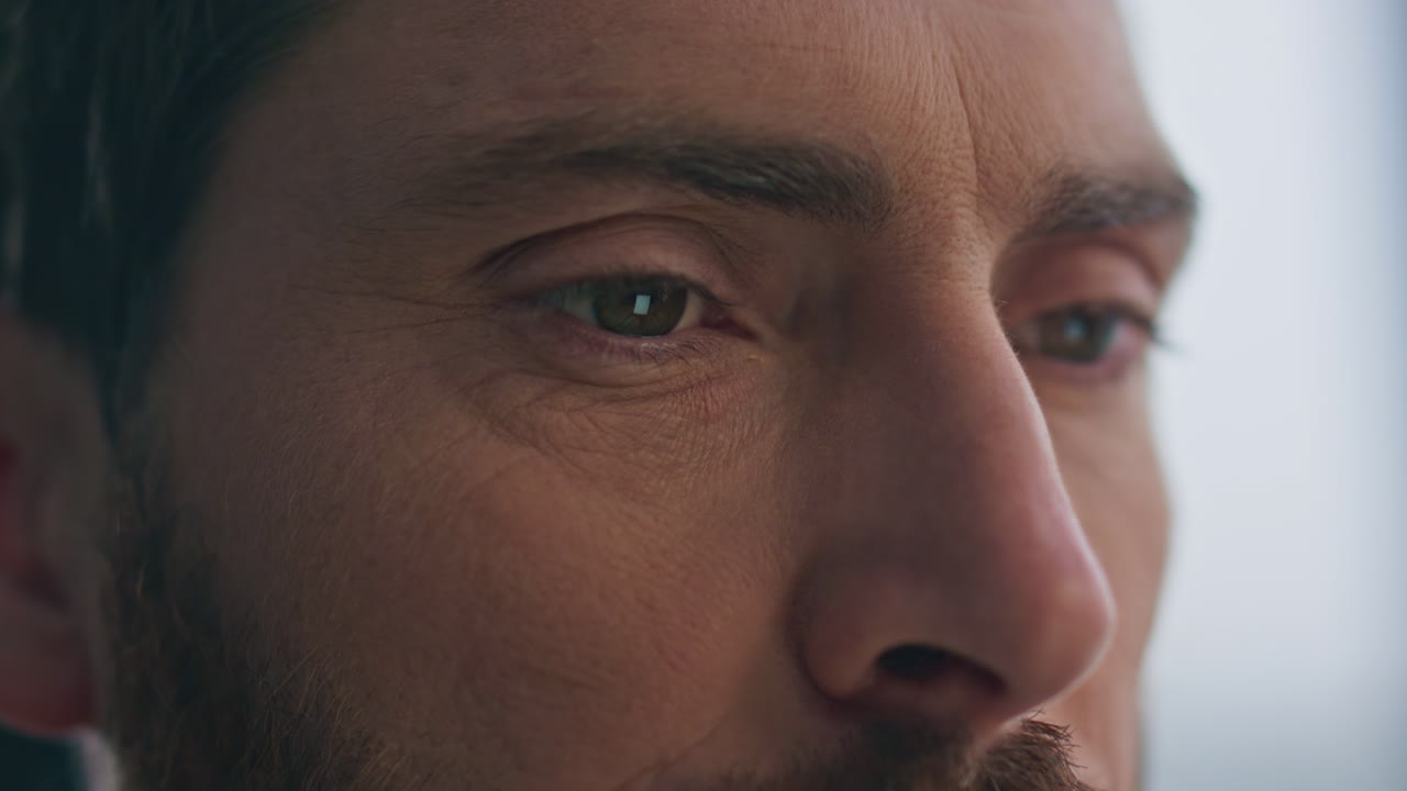 los ojos fruncidos del tipo mirando la pestaña mirando desde la distancia a casa de cerca. cara de hombre serio