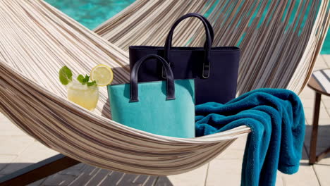 stylish handbags by the pool in a hammock